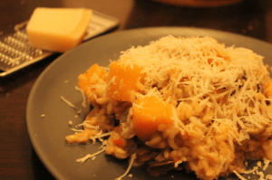 Homemade Spicy Pumpkin Risotto on a plate, in the background lays a Parmasan cheese