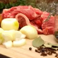 Ingredients for the beef stew recipe on a wooden plate