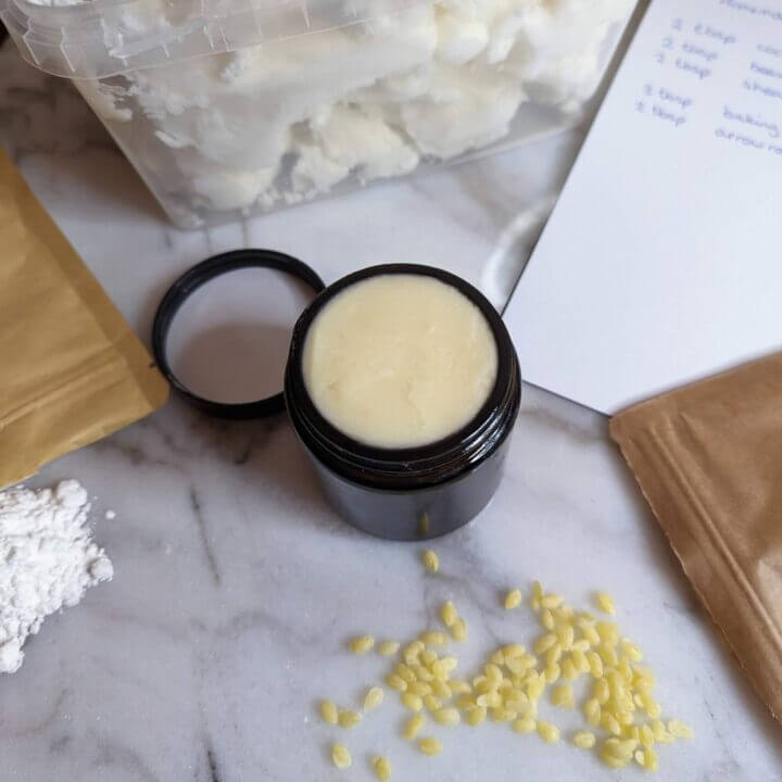 homemade deodorant next to beeswax, arrowroot powder, sheabutter and a note with the recipe written on it