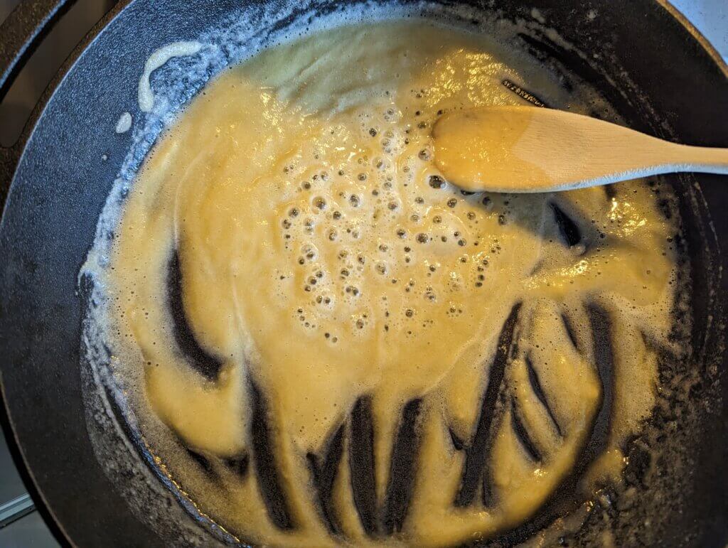 Roux in a skillet with a wooden spoon