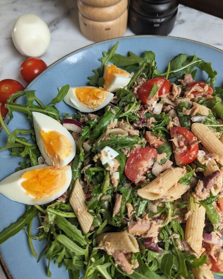 pasta salad nicoise with boiled eggs, tomatoes, and tuna