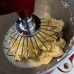 A mixing bowl of a red stand mixer with freshly mixed butter and butter milk
